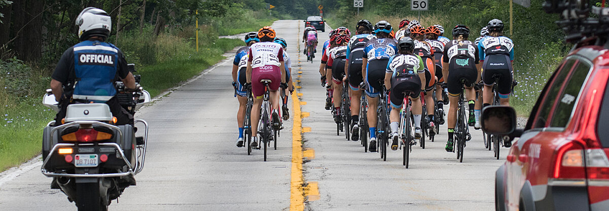 Road race with the official riding behind the cyclists.