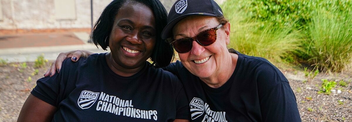 Two women in National Championship shirts hugging and smiling.