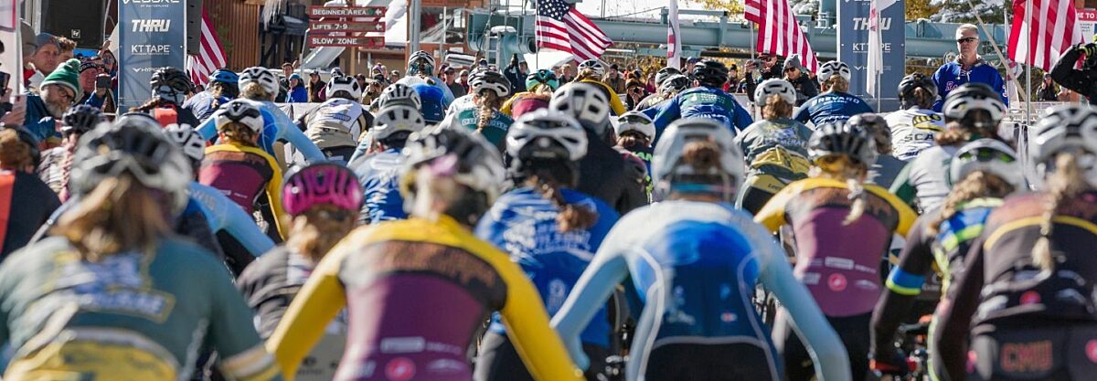 Collegiate race start line behind the riders as they start biking.