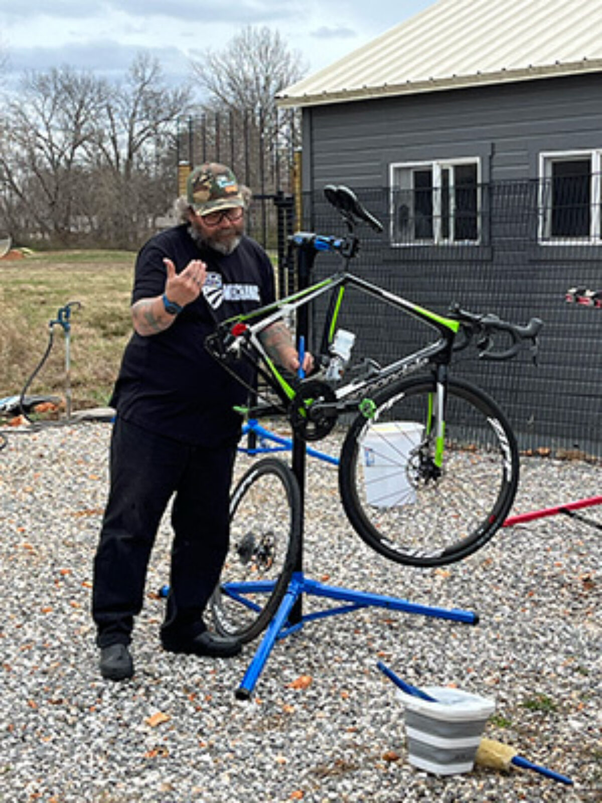 Mechanic taking care of a bike, washing it and preforming maintenance on it.