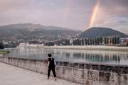 A woman walks on the banks of the Drina River, in Visegrad, Bosnia and Herzegovina, on July 8, 2025.