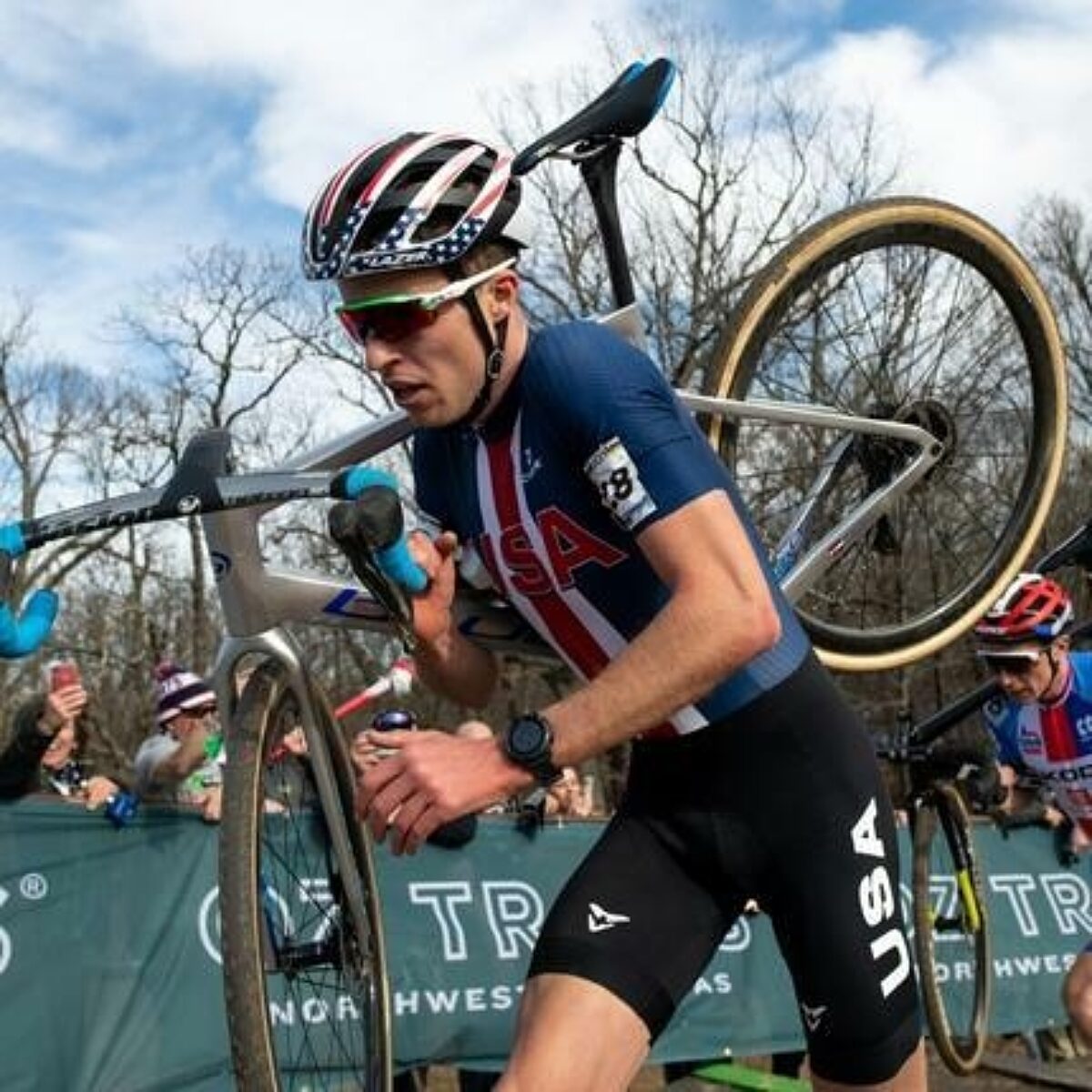 Cyclocross racer carrying his bike during a race.
