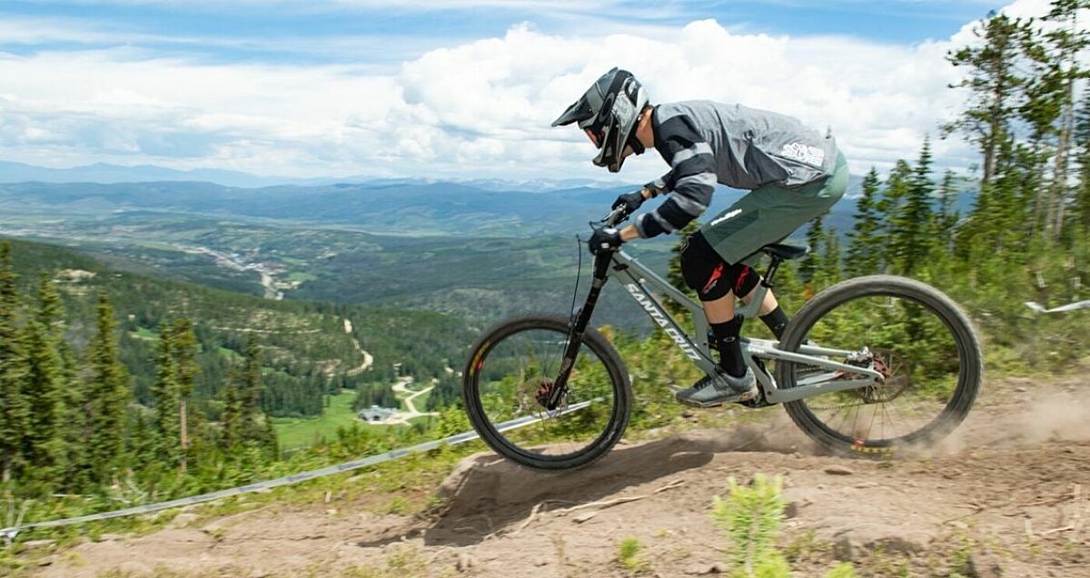 Downhill mountain biker going down a trail.