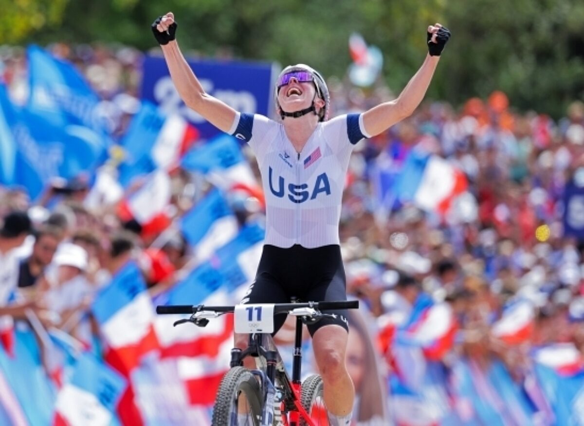 Haley Batten celebrating on her bike as she wins a race