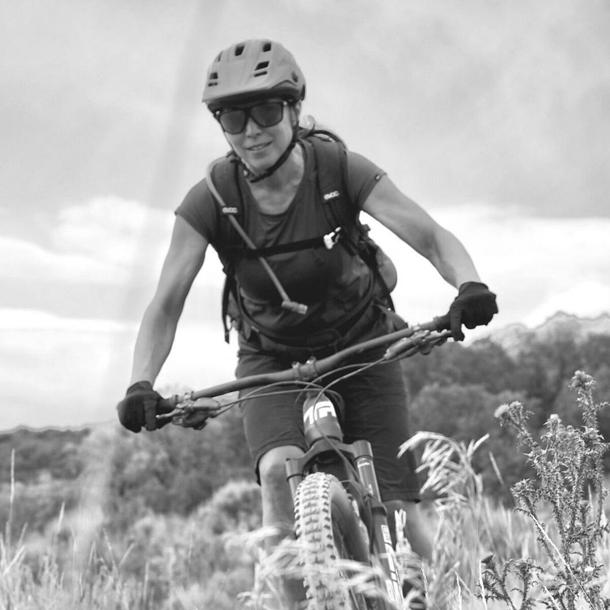 Melanie Strong rider her mountain bike through a field