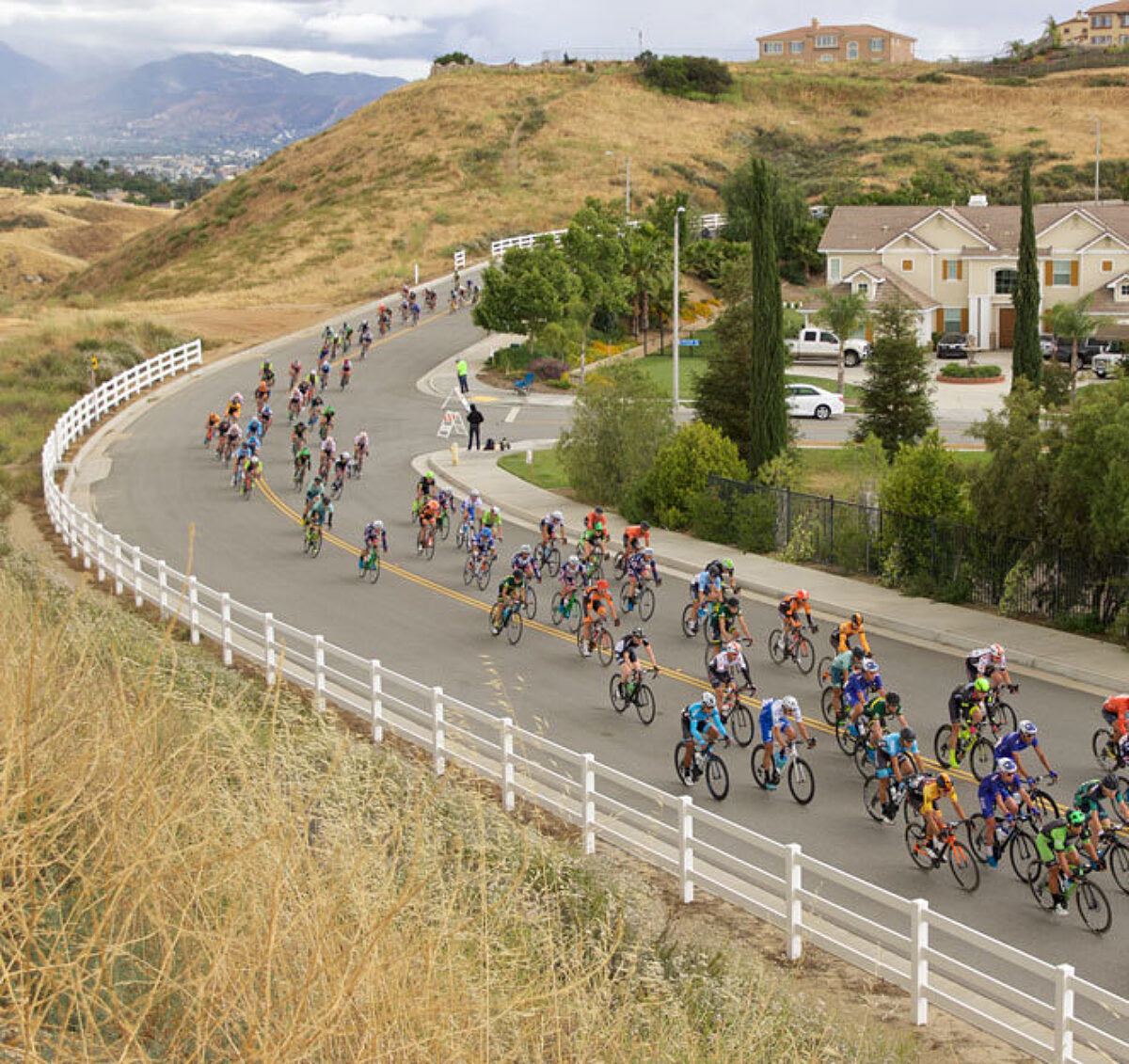Road racers going through a wide corner, shot from above to see the scope of the race.