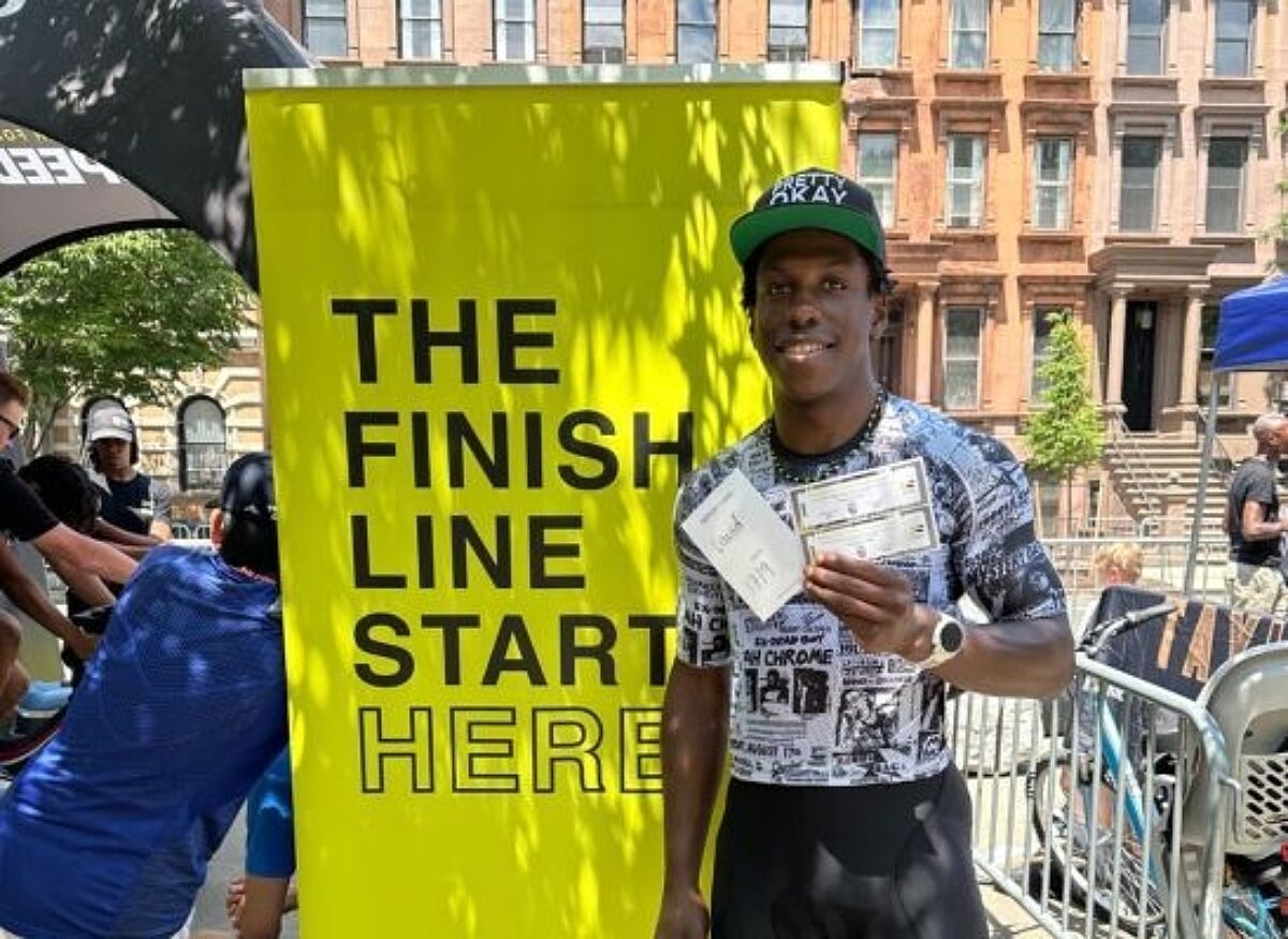Man posing next to Search for Speed poster