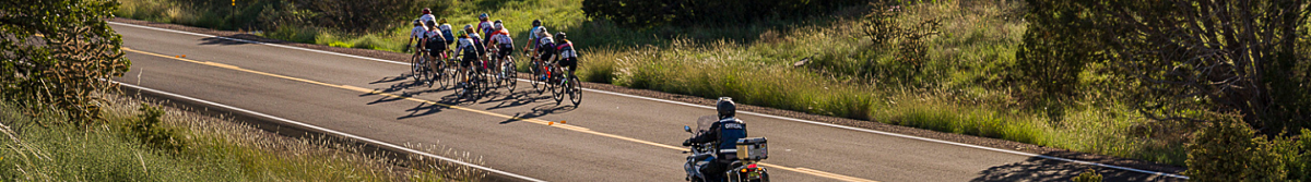 A man on a motorcycle following a group of bike racers